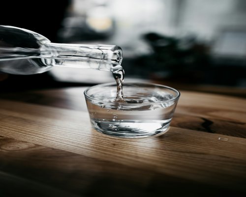 A person pouring a glass of water after a walk